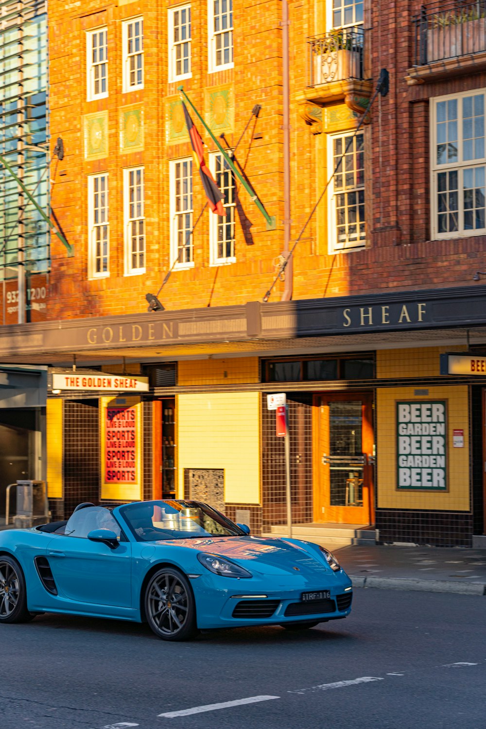 a blue sports car driving down a city street