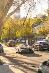 A family happily driving their car down a sunny suburban street.