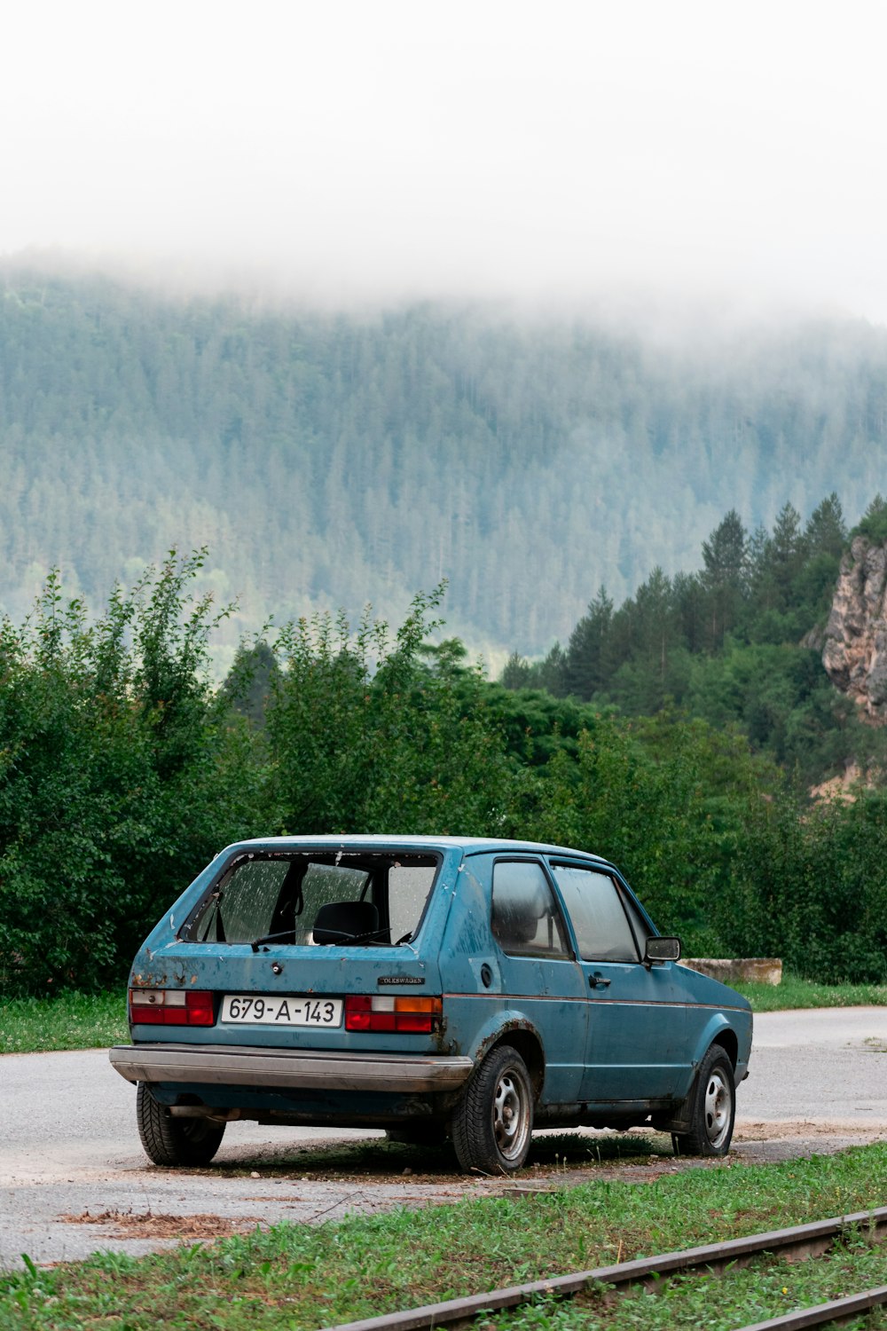 a blue car parked on the side of a road