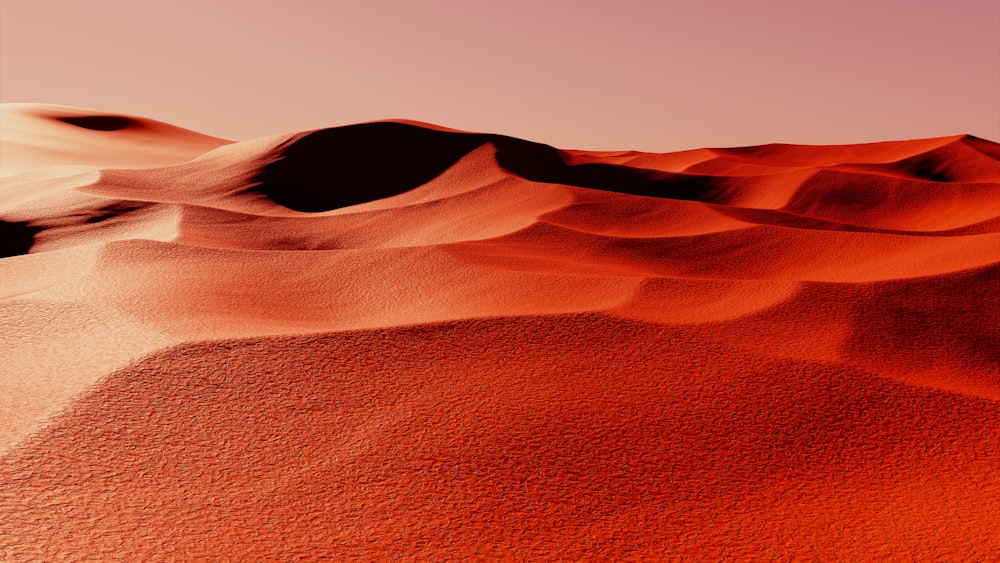 a desert landscape with sand dunes and a pink sky