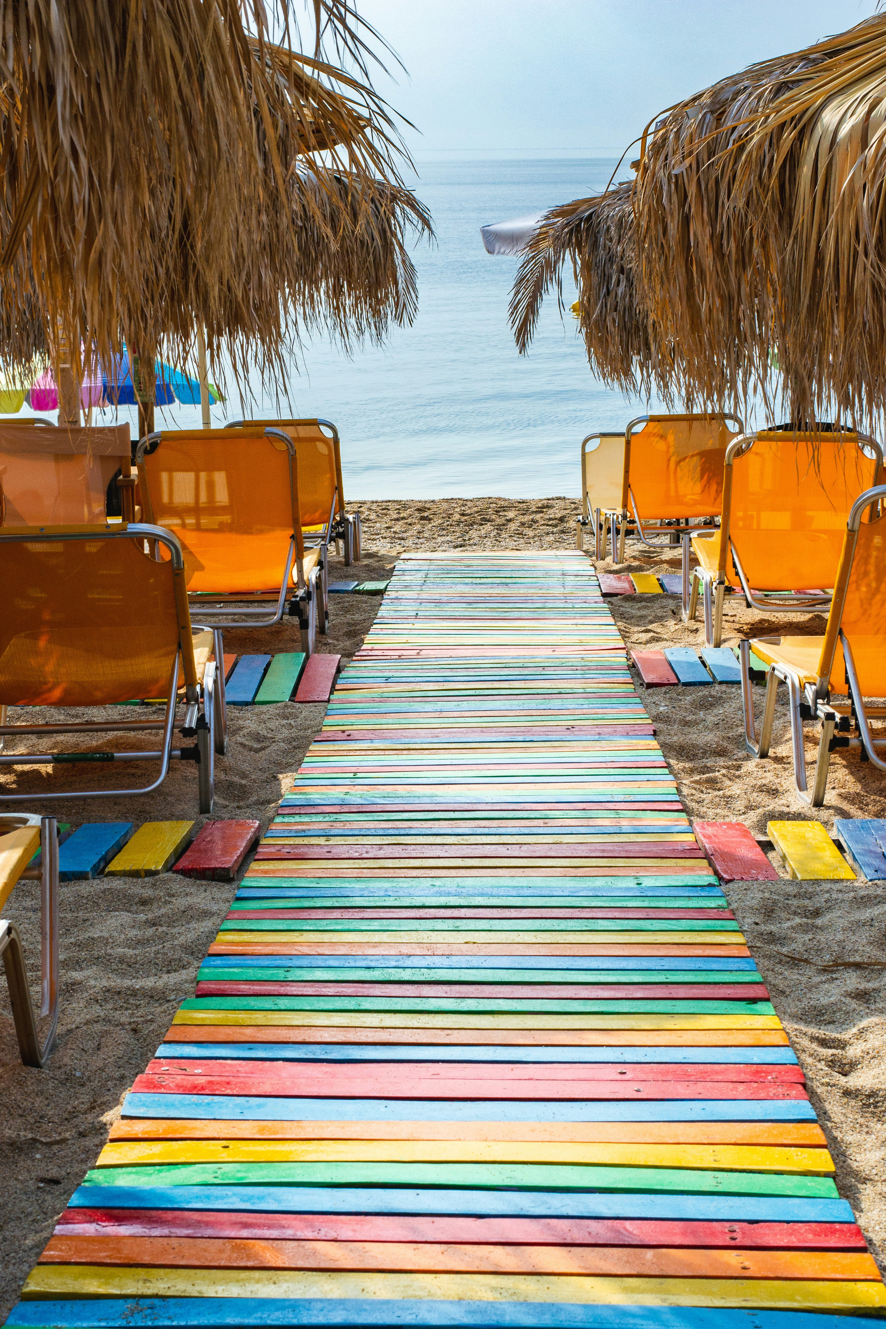 a colorful carpet on the beach with chairs and umbrellas