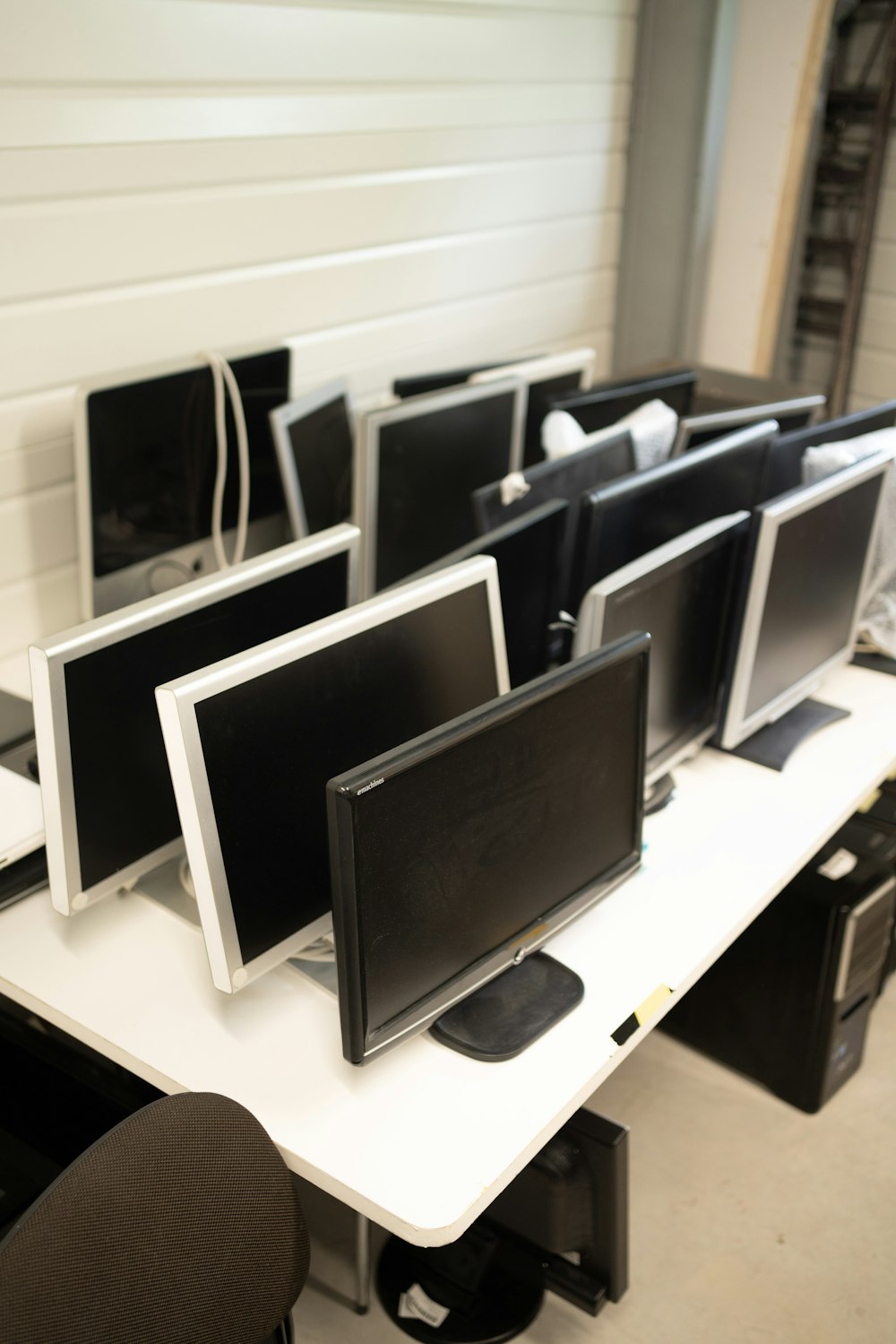 a row of computer monitors sitting on top of a desk
