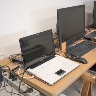 a desk with two laptops and a keyboard on it