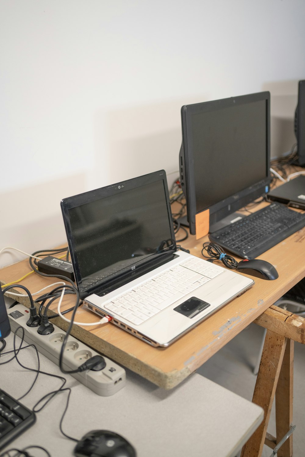 a desk with two laptops and a keyboard on it