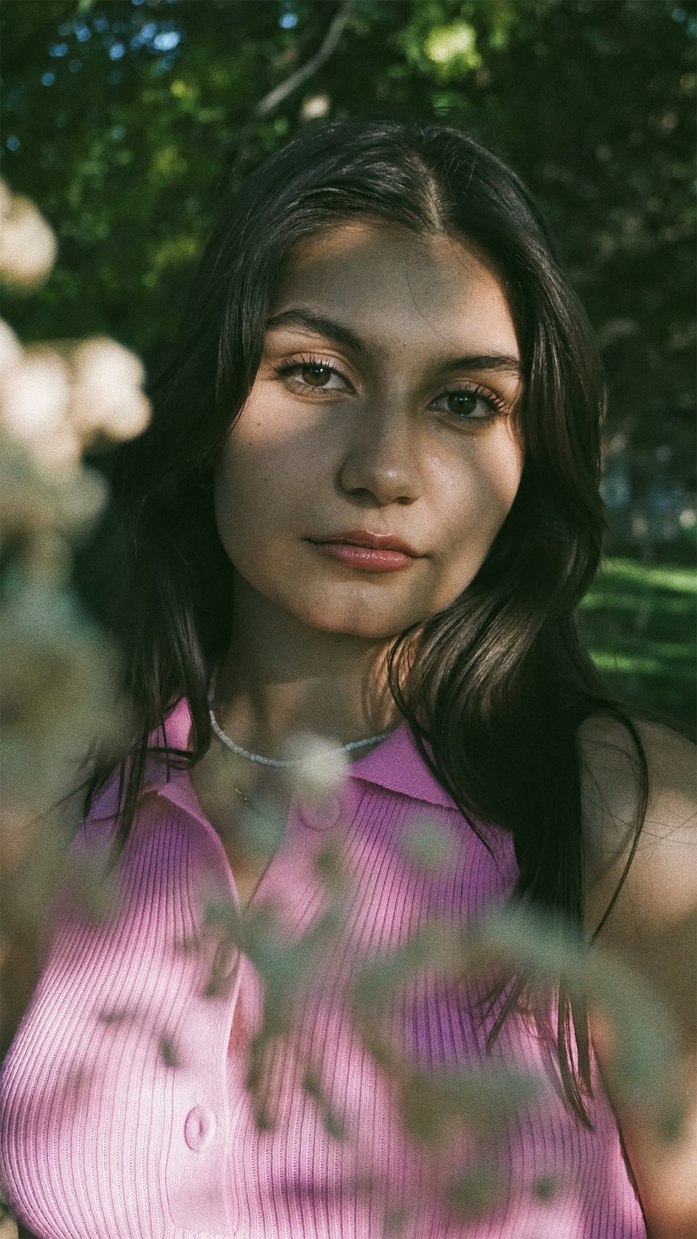 Eine Frau in einem rosa Hemd posiert für ein Foto