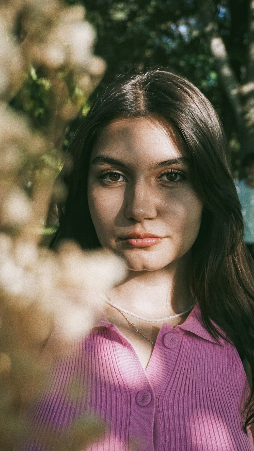 Eine Frau in einem rosa Hemd posiert für ein Foto