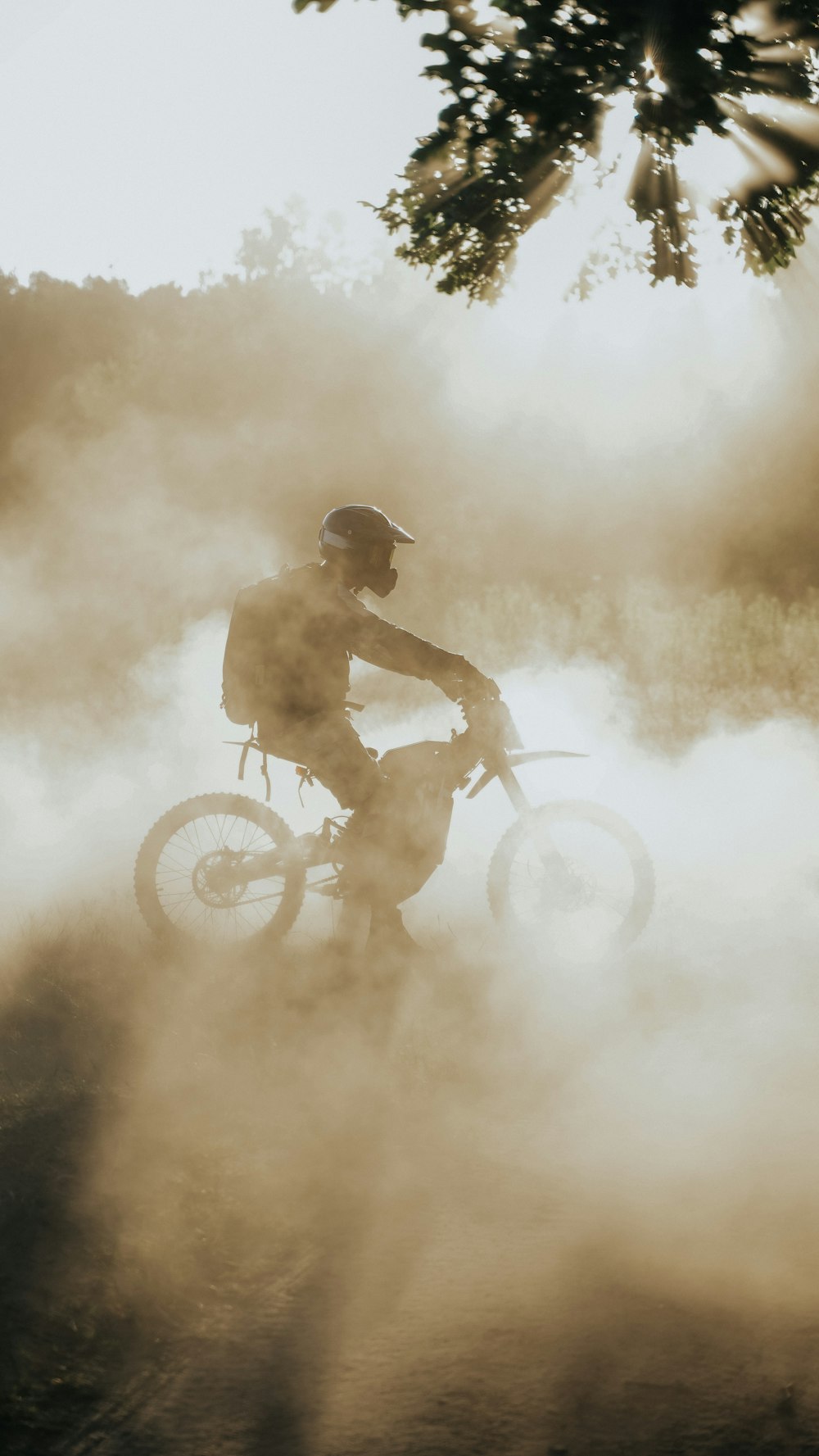 a man riding a dirt bike through a cloud of smoke