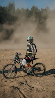 a man riding a dirt bike on top of a dirt field
