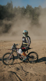 a man riding a dirt bike on top of a dirt field