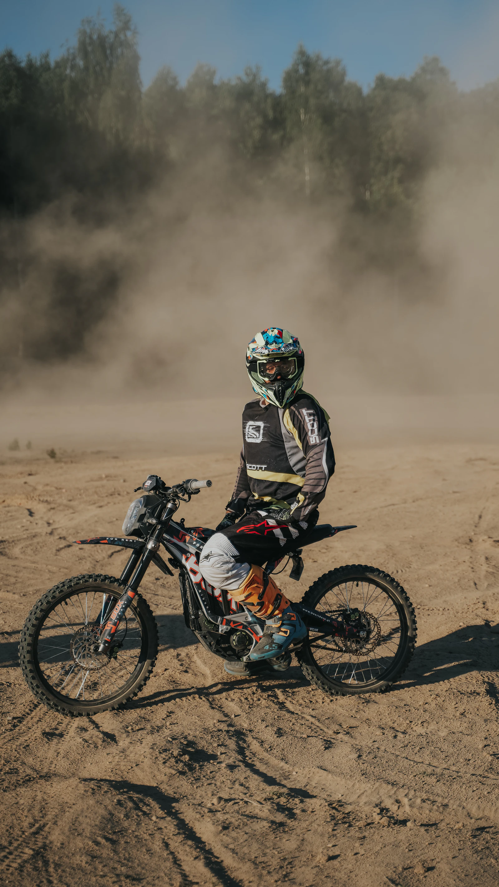 Rider on a custom electric dirt bike in the dust