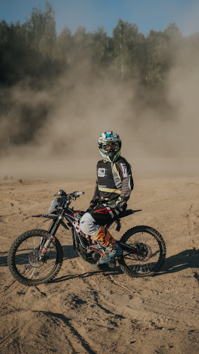 a man riding a dirt bike on top of a dirt field