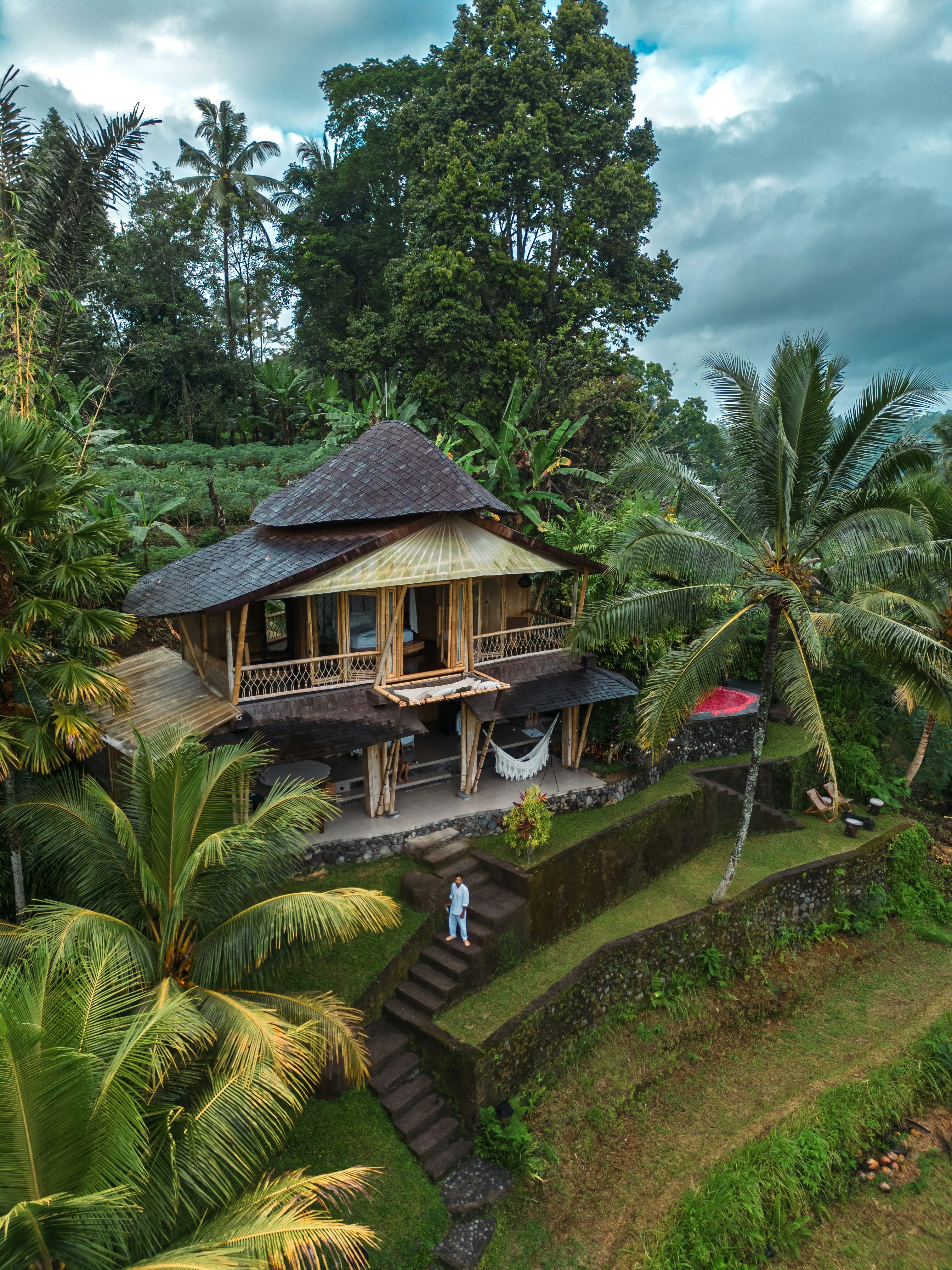 A luxurious private villa with a stone wall and lush greenery in Bali.