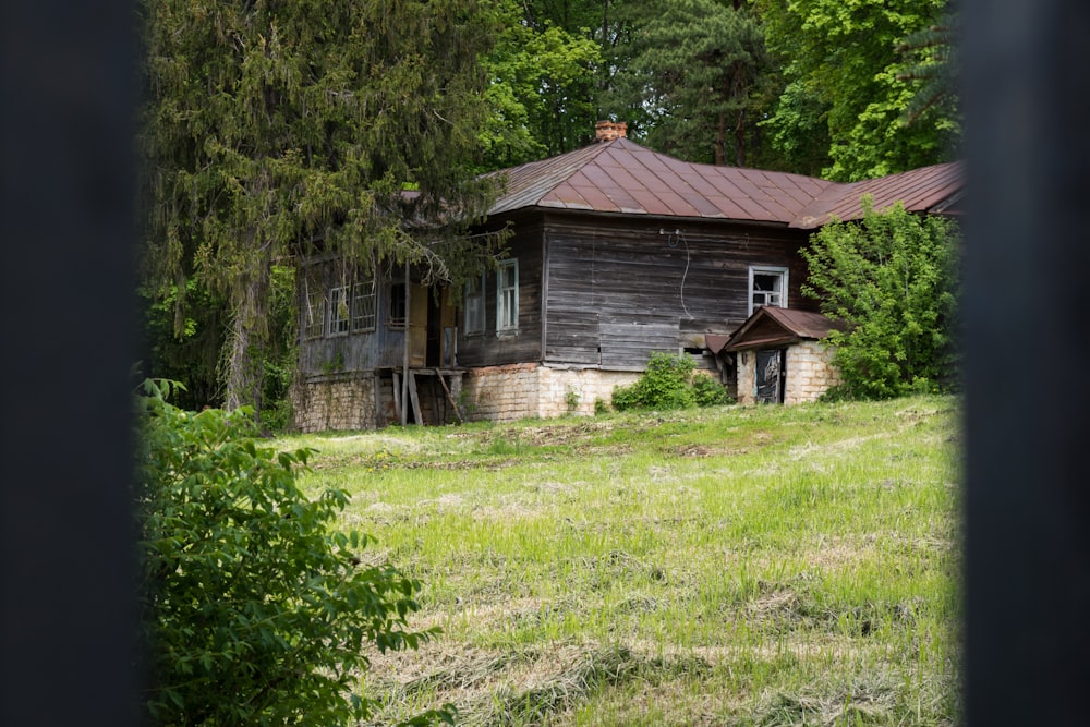 an old run down house in the middle of a field