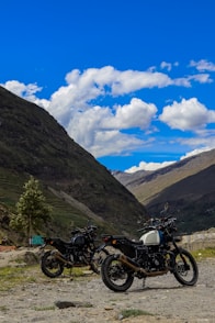 two motorcycles parked on the side of a road