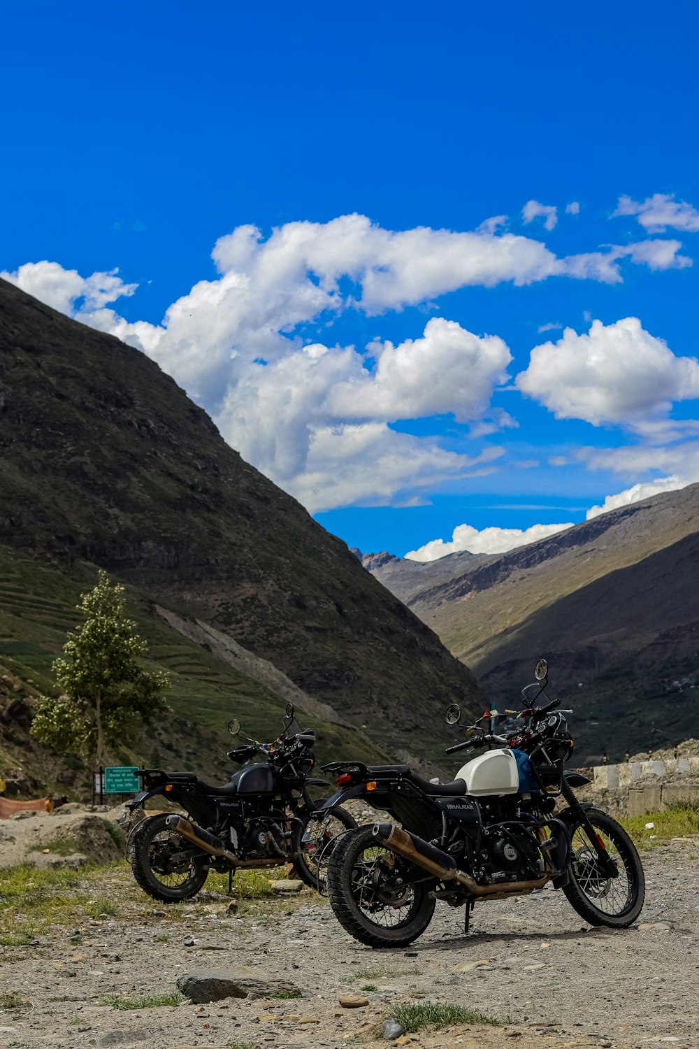 two motorcycles parked on the side of a road