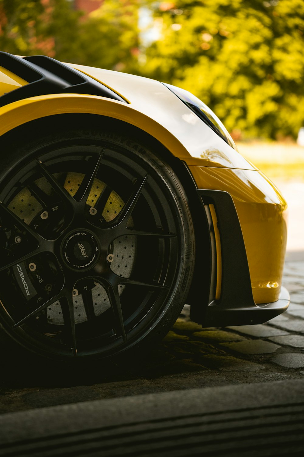 a yellow sports car parked on the side of the road