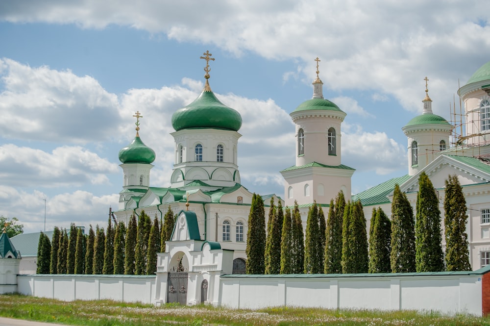 a large white building with green domes on top of it