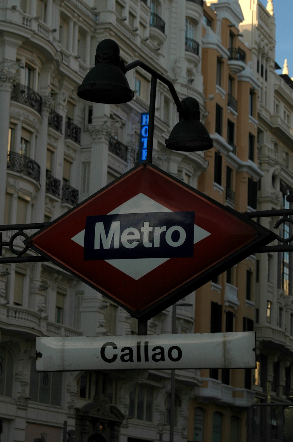 a metro sign hanging off the side of a building