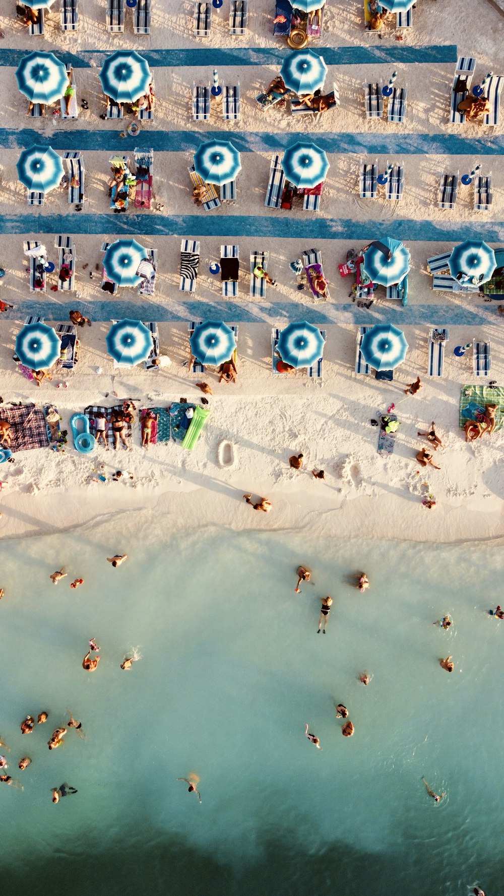 an aerial view of a beach with umbrellas and people