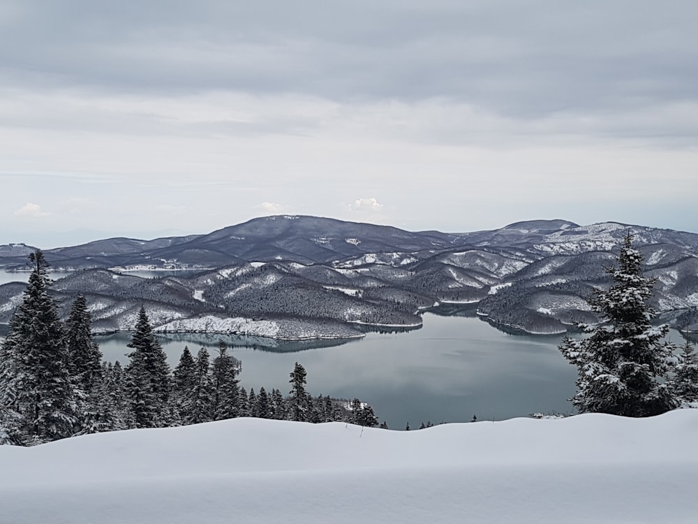 a snow covered mountain with a lake in the middle