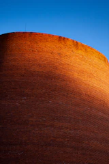 Construction workers building a sturdy brick wall on a sunny day.