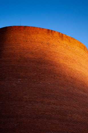 Construction workers building a brick wall on a sunny day.