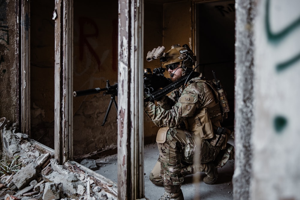 a man in camouflage with a machine gun