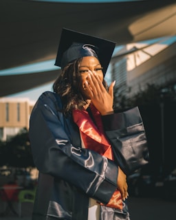 Candid shot of a graduate wiping a tear of joy during the ceremony.