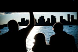 A confident family smiling in front of an iconic global city skyline at sunset.