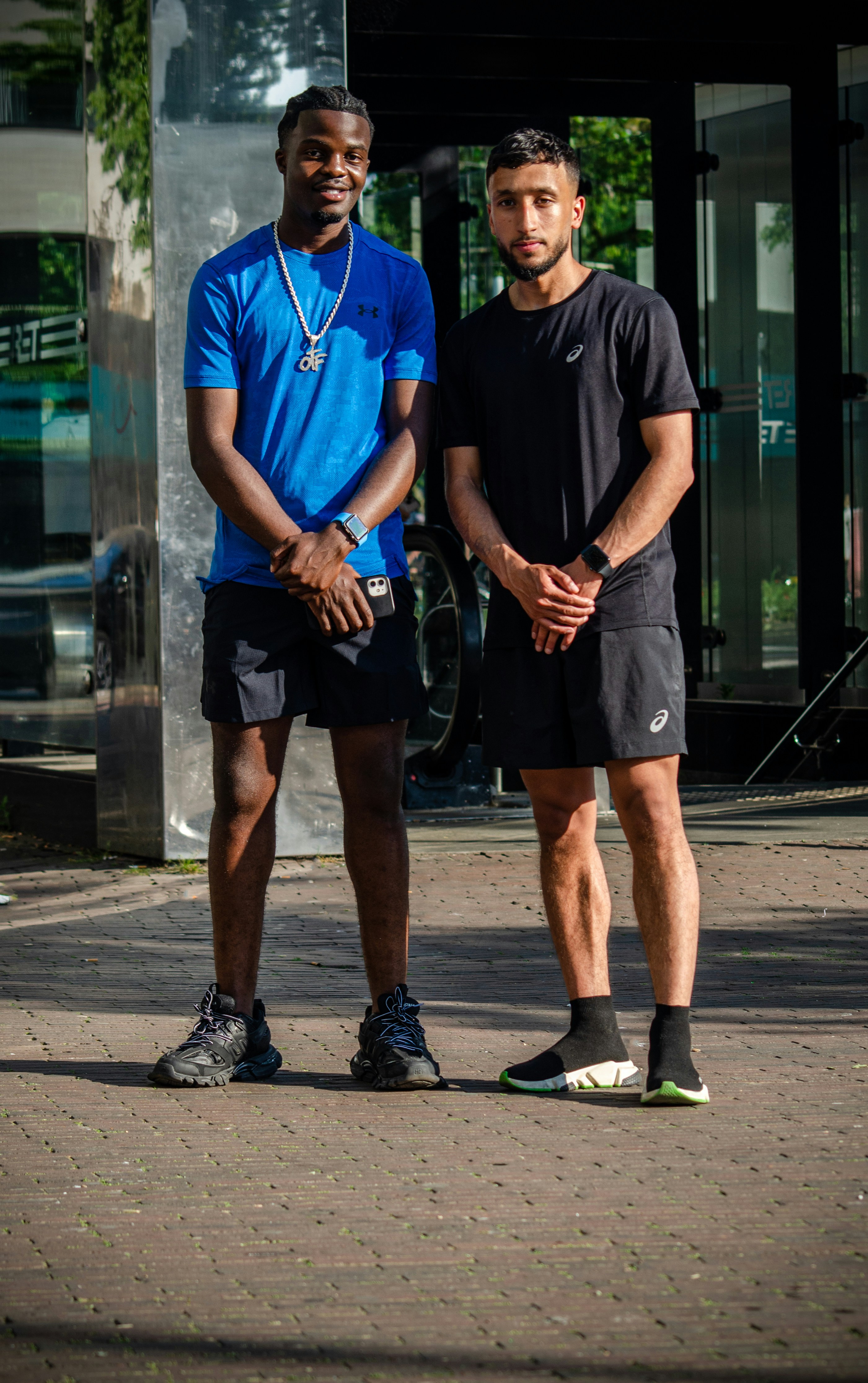 Two men standing next to each other in front of a building photo – Free ...
