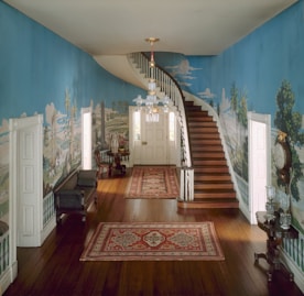 a hallway with a staircase and a painting on the wall