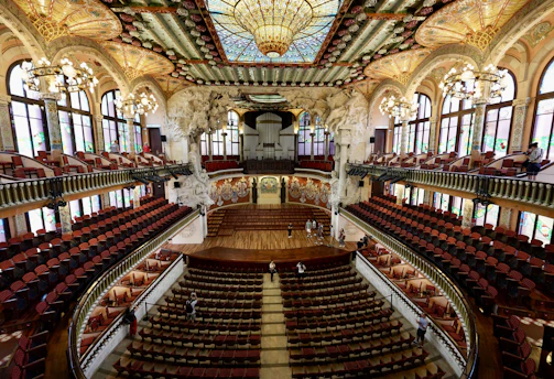 An old concert hall with wooden seats and ornate decorations.