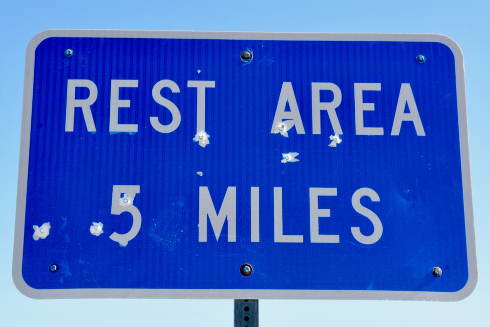 a blue sign that says rest area 5 miles