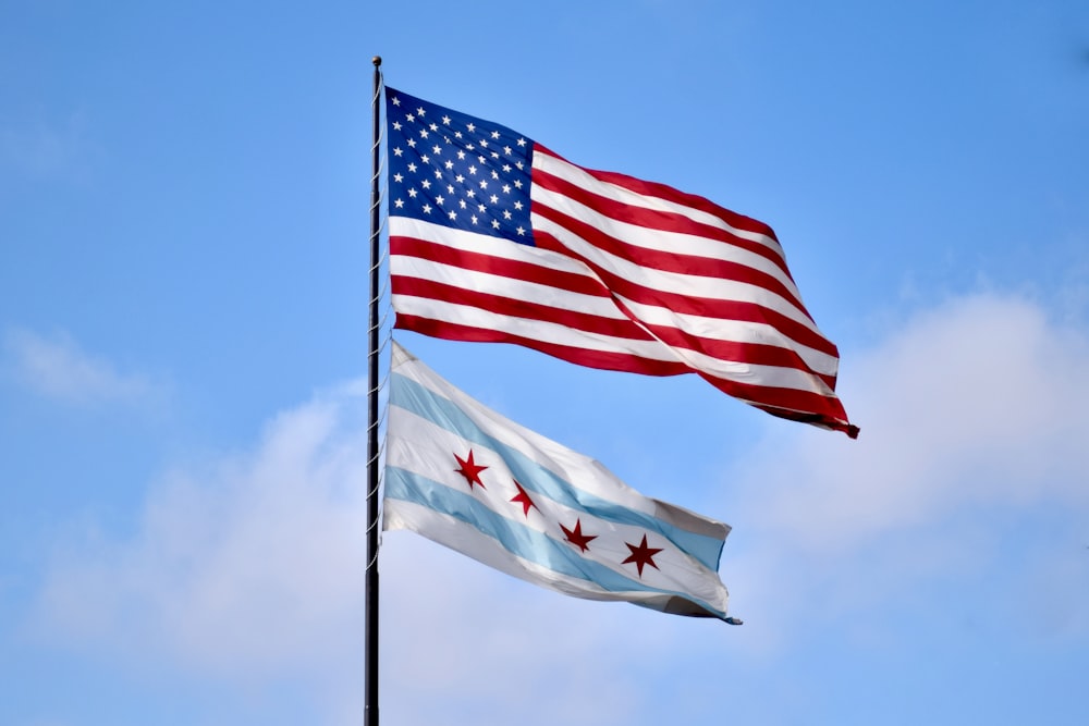 two american and canadian flags flying side by side