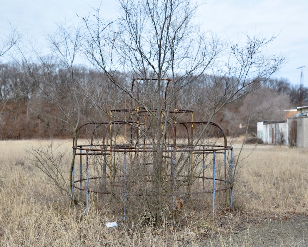 a rusted out metal structure sitting in a field