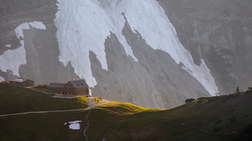 a snow covered mountain with a house in the foreground