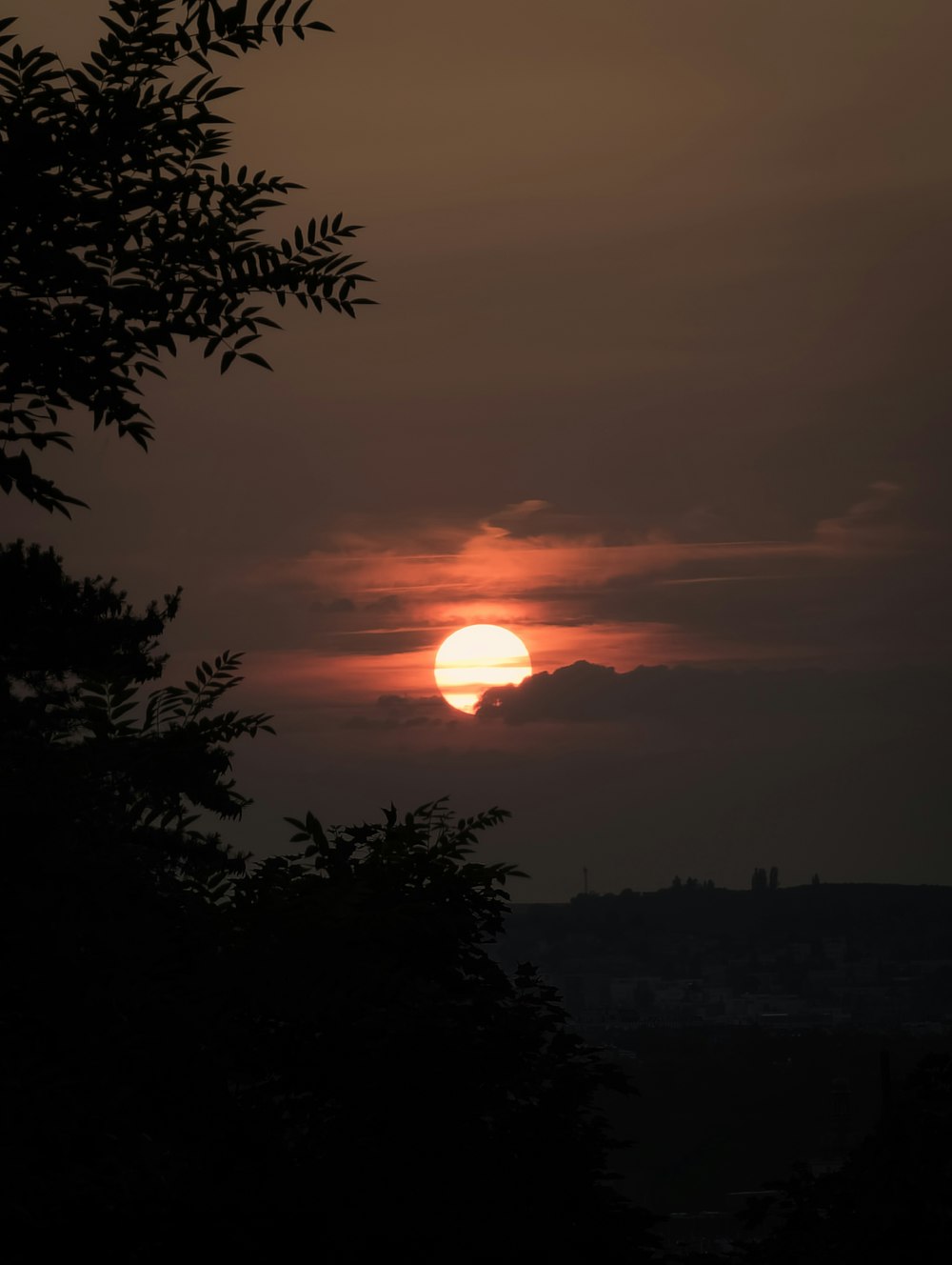 the sun is setting over the horizon of a city