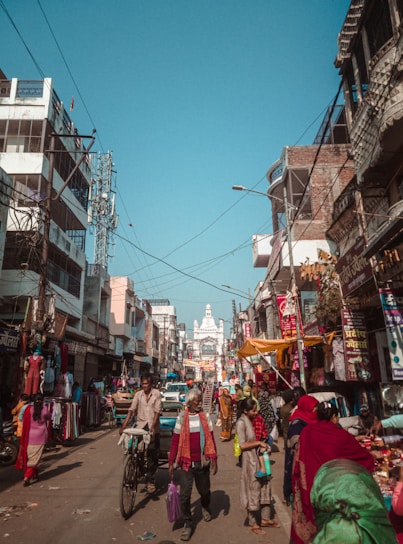 A vibrant street scene in Bikaner showing local shops bustling with customers using their phones.