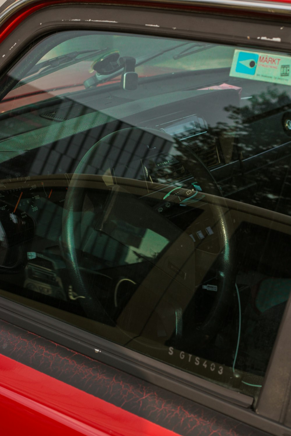 a red car parked next to a parking meter