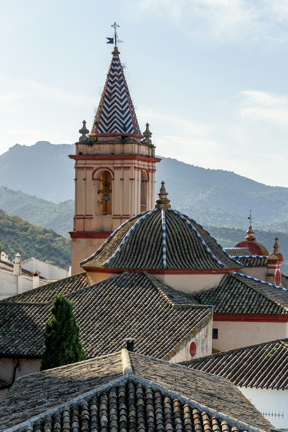a view of a building with a clock tower and mountains in the background