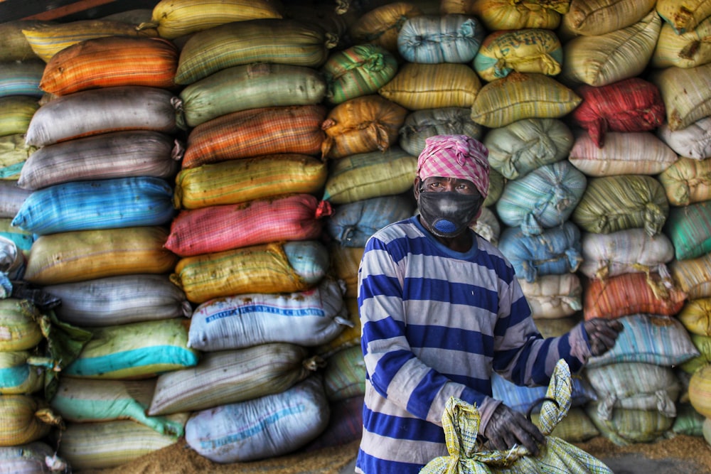 a man standing in front of a pile of bags