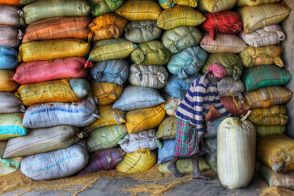 a man standing next to a pile of bags