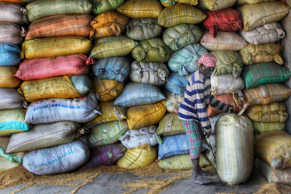 Warehouse workers organizing bags of animal feed ingredients ready for shipment.