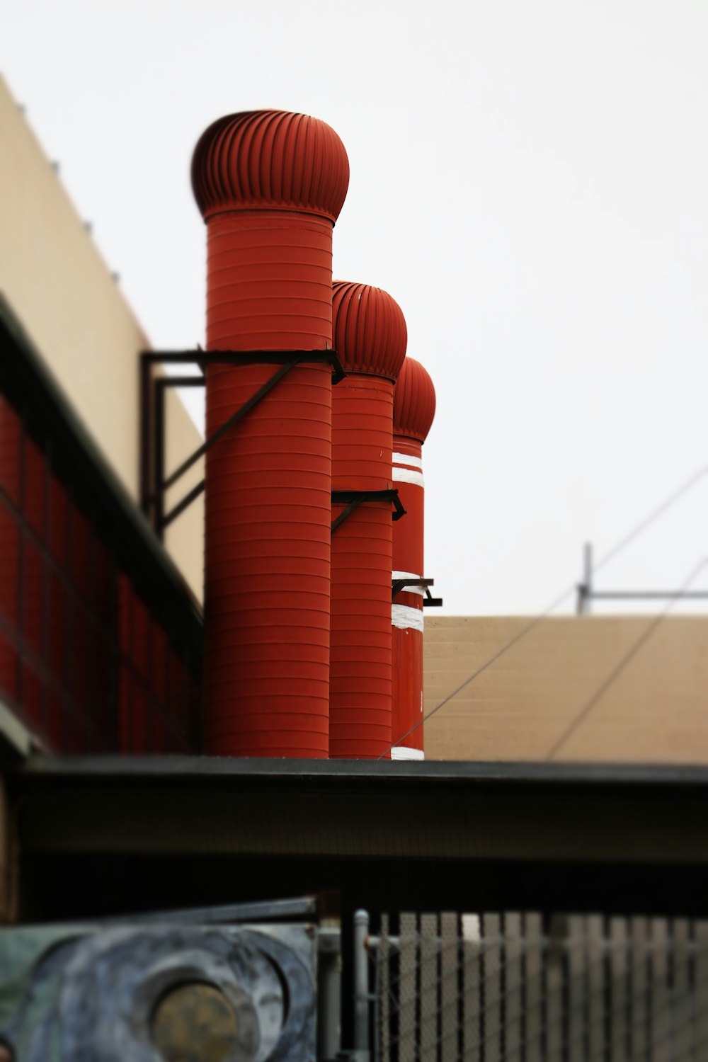 a row of red pipes on top of a building