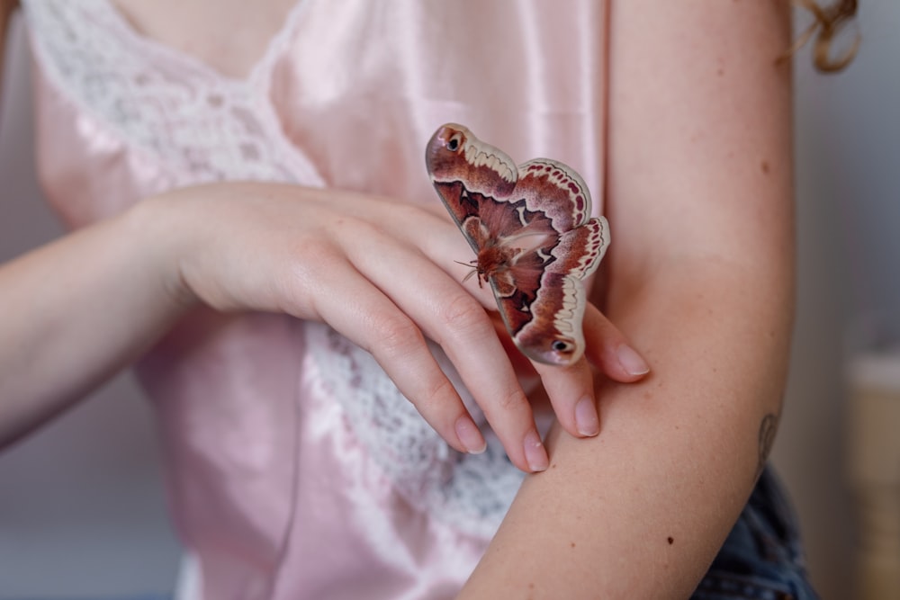 a woman holding a butterfly in her hand