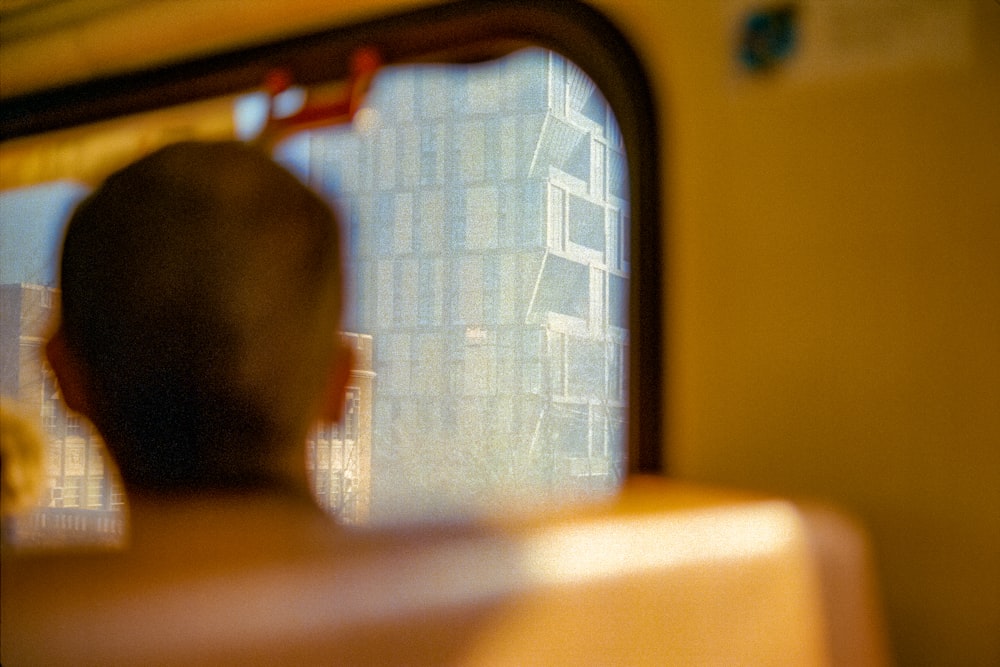 a man looking out the window of a train
