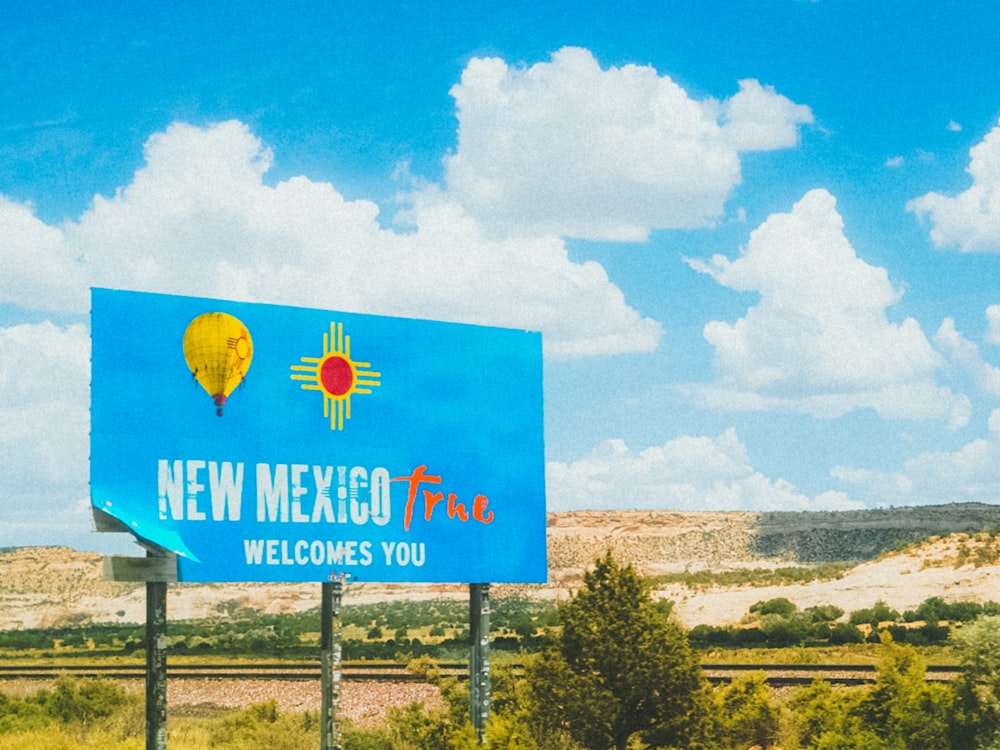 a blue sign that says new mexico plaza welcomes you