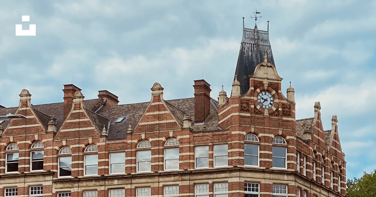 A large brick building with a clock tower on top photo – Free ...