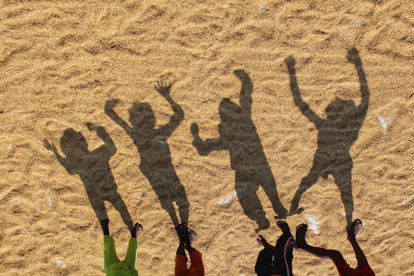 a group of people standing on top of a sandy beach