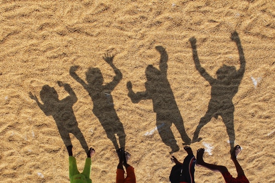 a group of people standing on top of a sandy beach